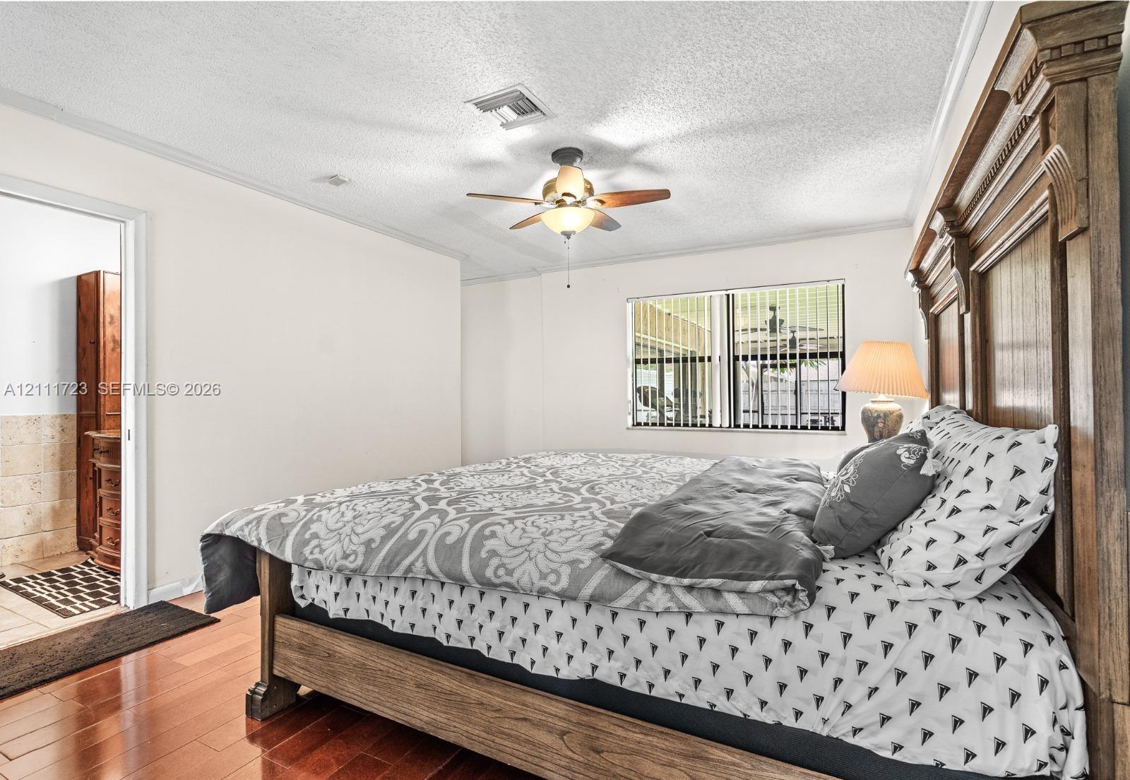 Wood-finish flooring, ceiling fan with integrated lighting, and horizontal window blinds