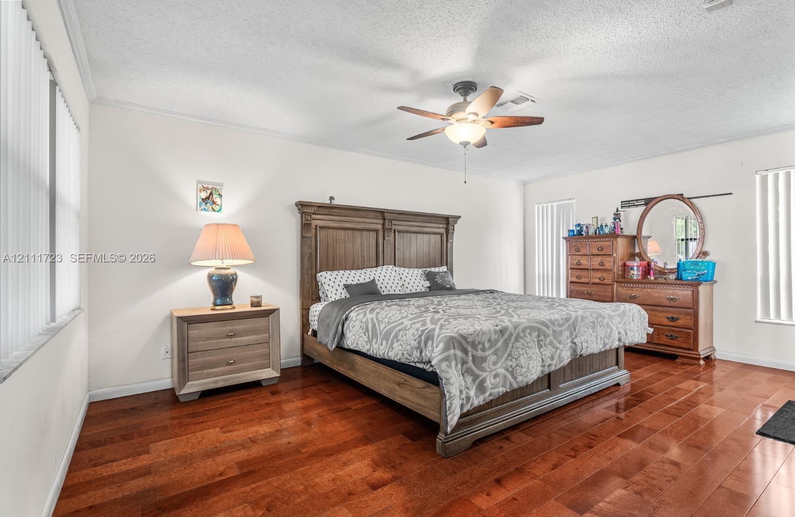 Wood-finish flooring, ceiling fan with integrated light fixture, and vertical blinds