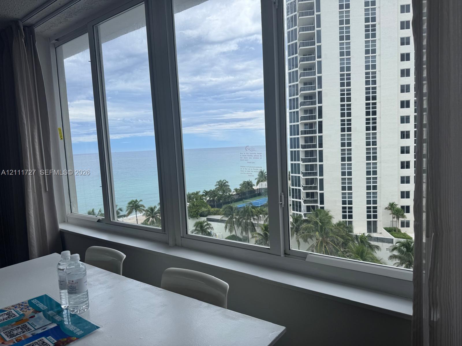 Expansive floor-to-ceiling windows featuring white metal framing and a wide interior sill Expansive floor-to-ceiling windows featuring white metal framing and a wide interior sill