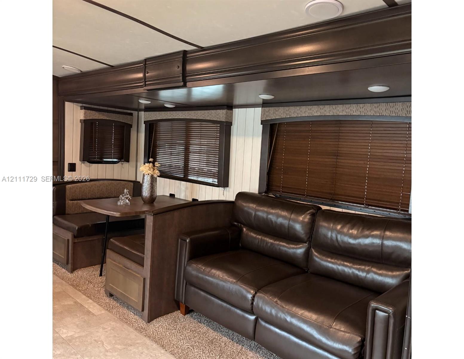 Vertical-paneled wall accents, horizontal wood blinds, integrated recessed lighting, and a dark-finish cabinetry valance