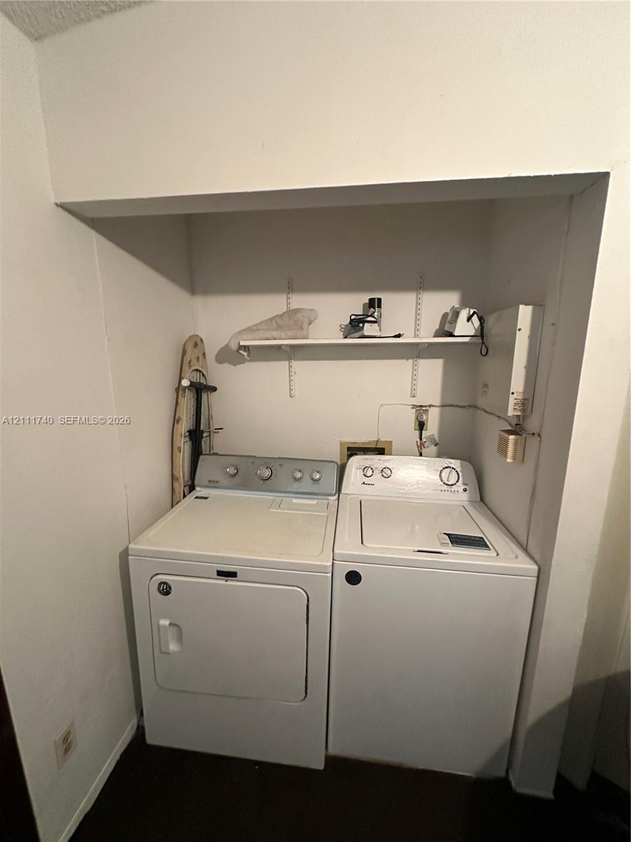 Laundry alcove featuring built-in shelving with adjustable wall-mounted tracks