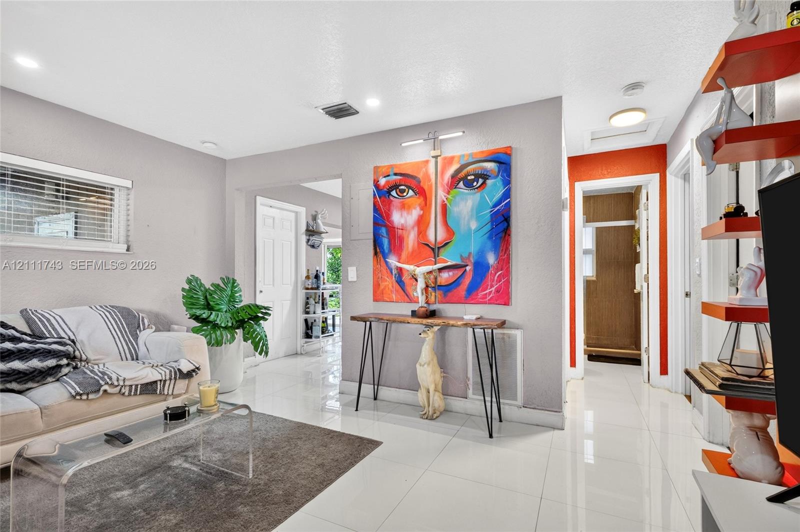 Neutral-toned interior featuring polished tile flooring, recessed lighting, and wall-mounted picture lighting