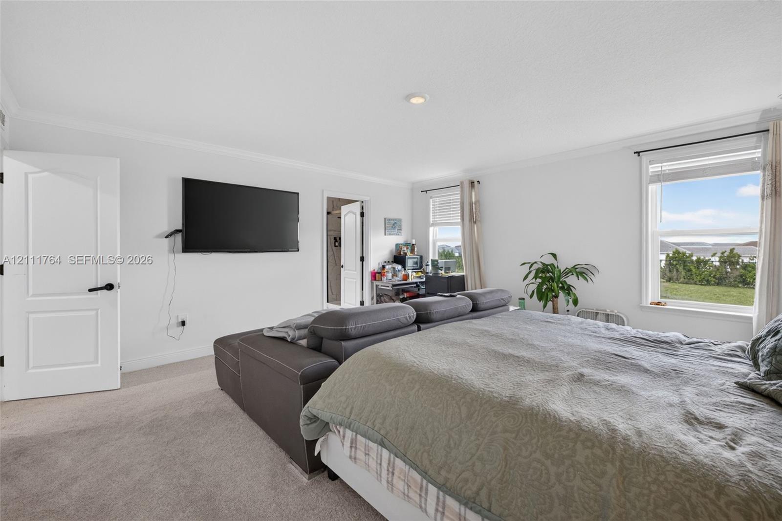 Neutral wall coloring, carpeted flooring, recessed lighting, and multiple windows with exterior exposure