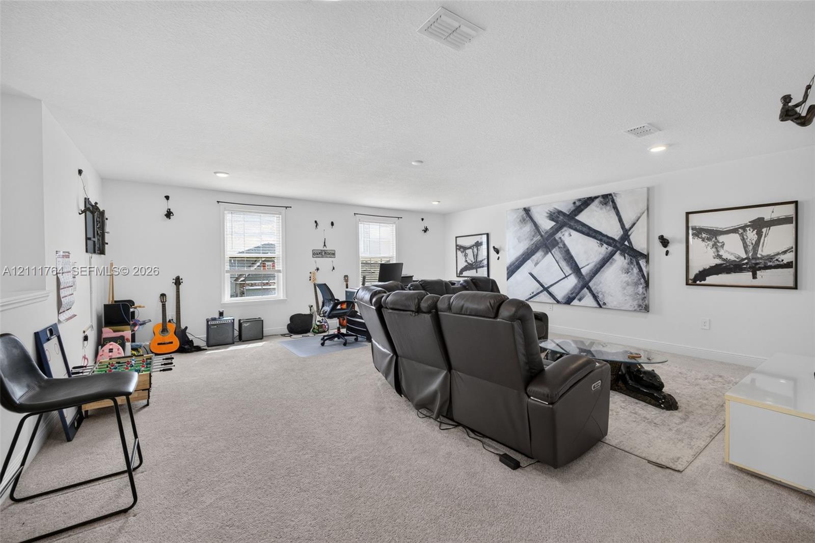 Expansive bonus room featuring neutral carpeting, recessed lighting, and multiple windows