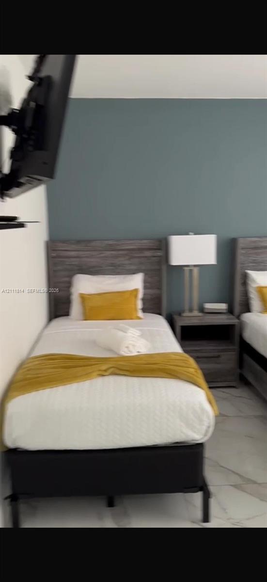 Accent wall painted in a muted blue tone, complemented by light-colored flooring with stone-patterned tile