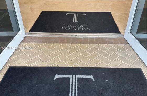 Entryway featuring glass-paneled double doors and herringbone-patterned stone paver flooring Entryway featuring glass-paneled double doors and herringbone-patterned stone paver flooring