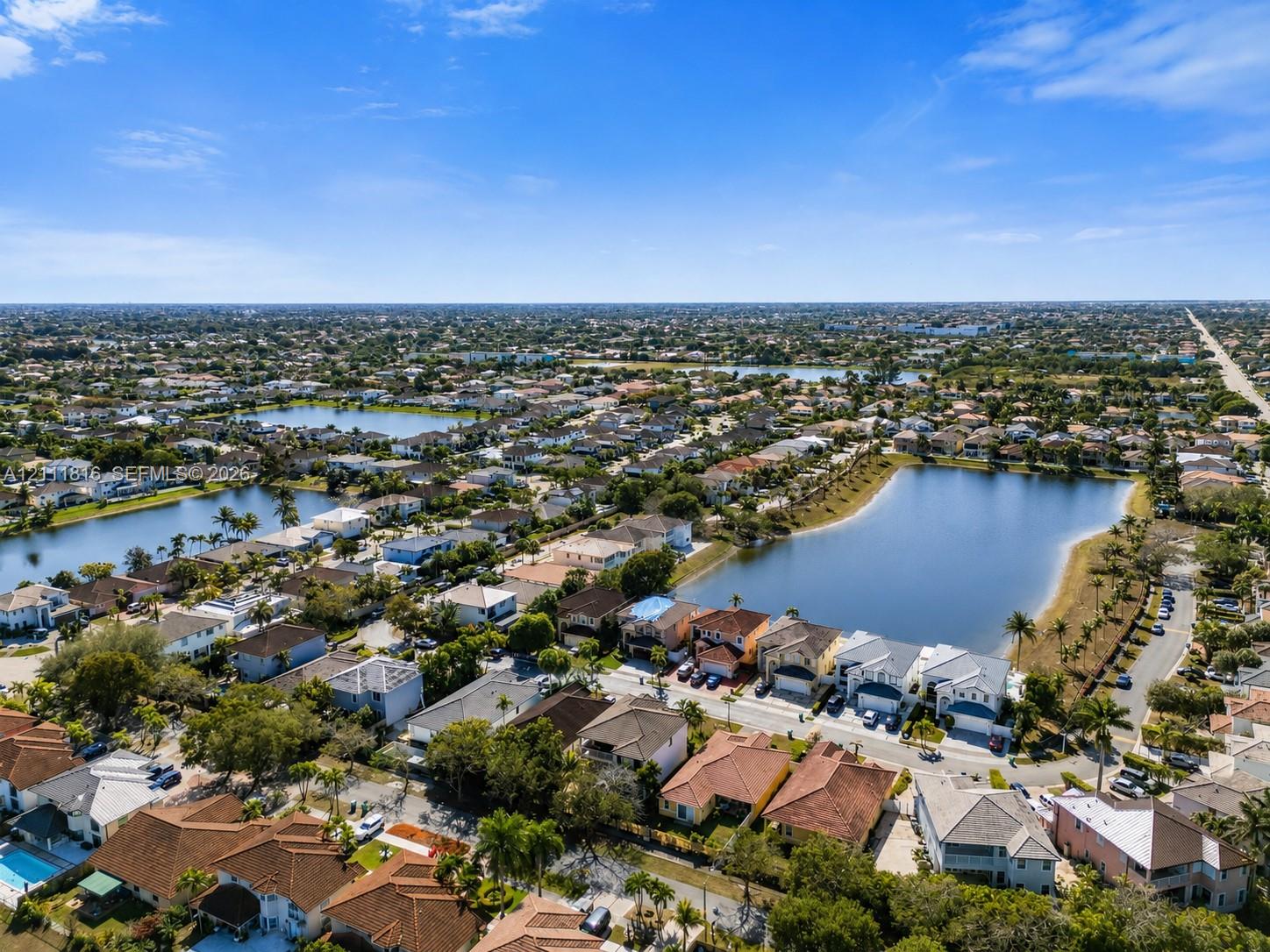Aerial perspective of a residential neighborhood featuring multiple community lakes and mature landscaping