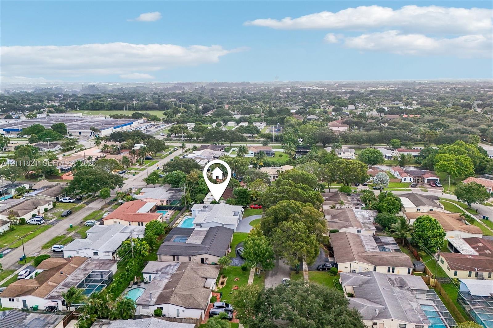 Aerial perspective of a property featuring an in-ground swimming pool and a paved driveway