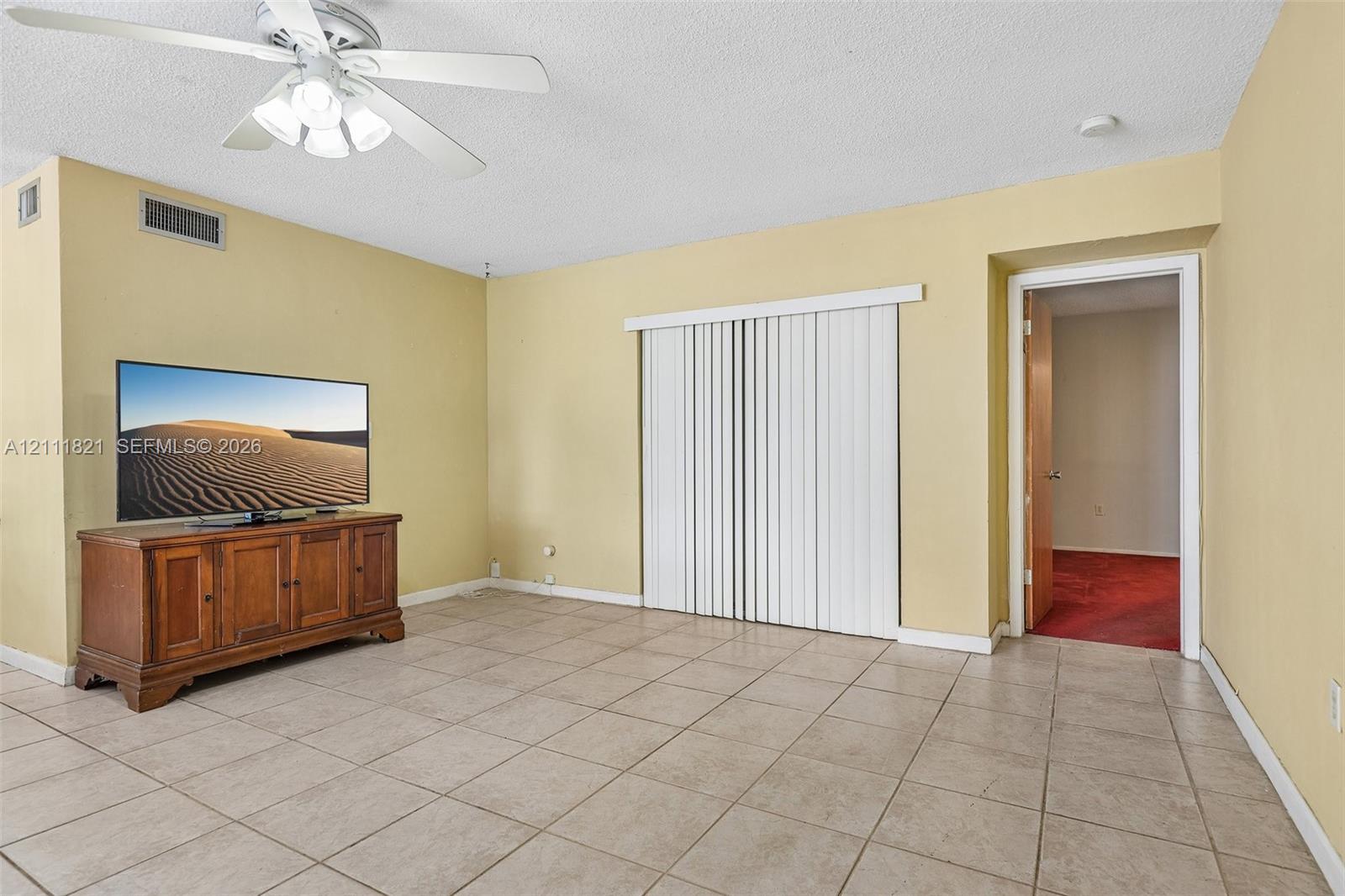 Tile flooring, ceiling fan with integrated lighting, and vertical window blinds