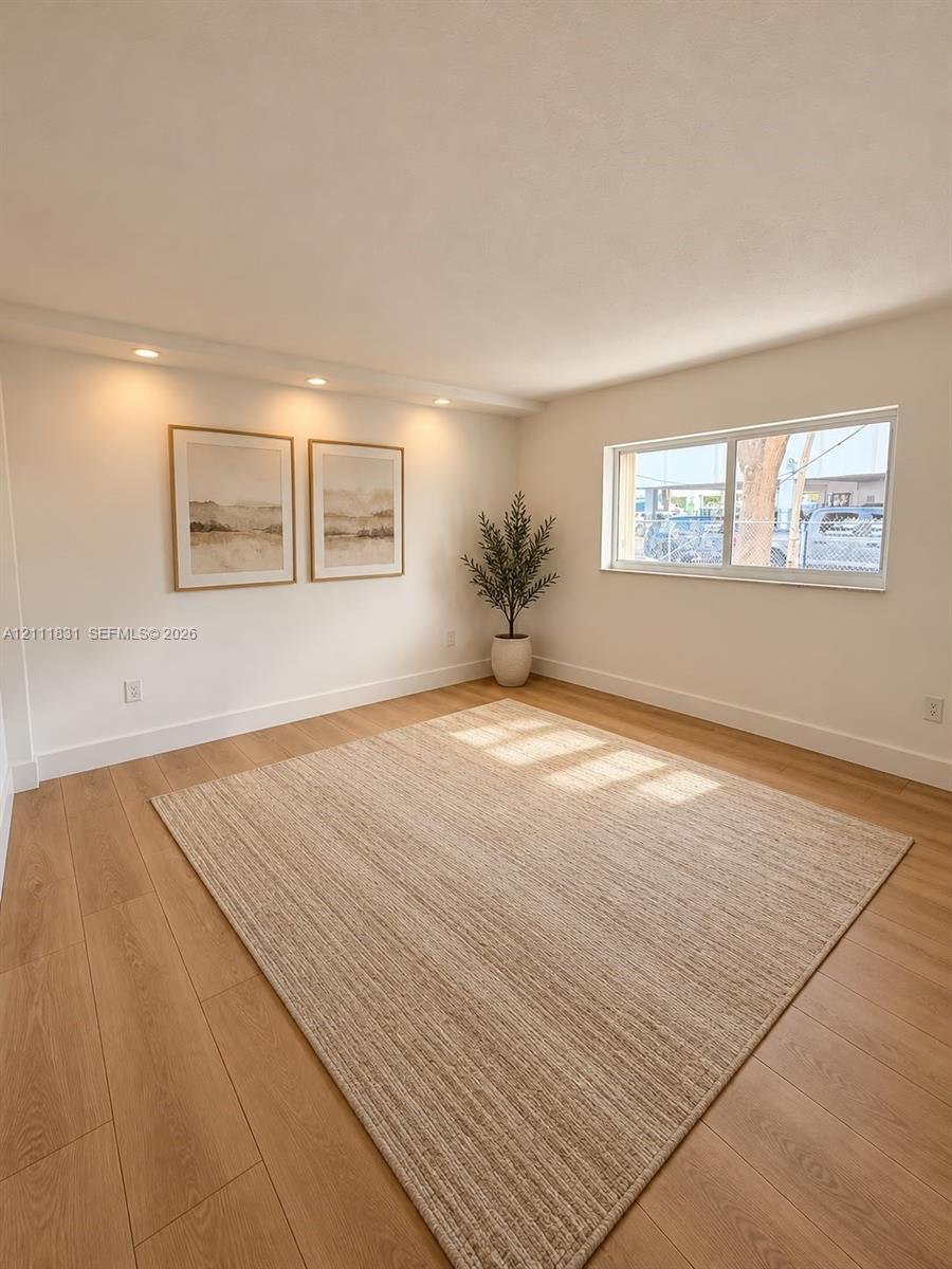 Bright room featuring wood-finish flooring, recessed lighting, and a large horizontal sliding window