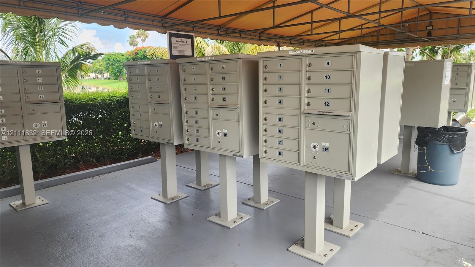 Covered exterior mail station featuring powder-coated metal pedestal boxes and a protective canopy