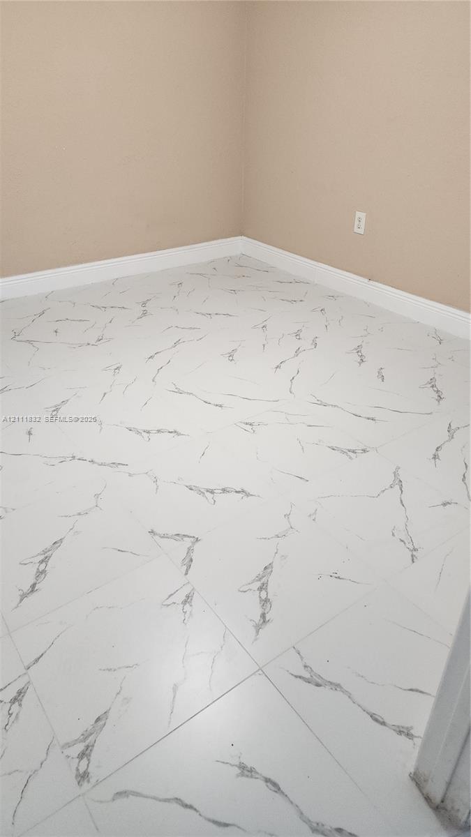 Large-format tile flooring featuring a white finish with grey veining patterns