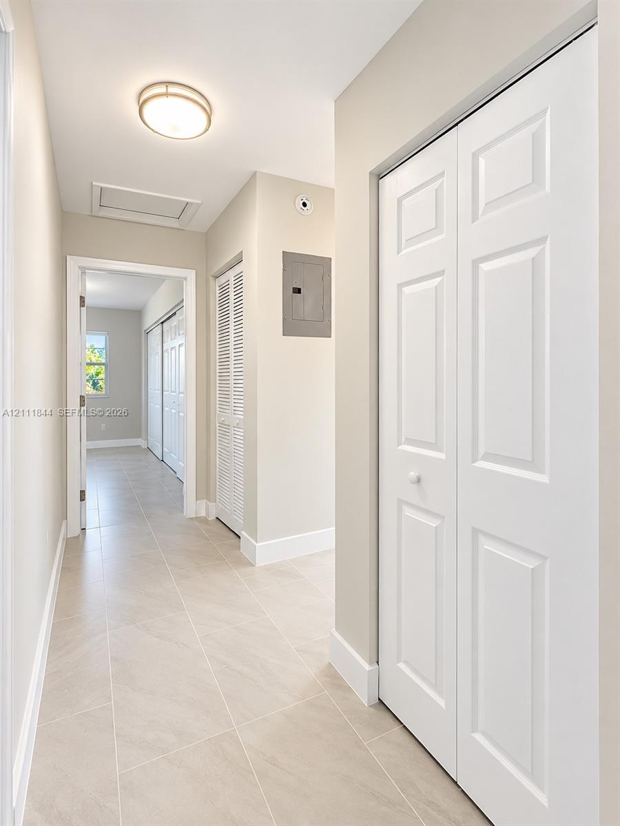 Neutral-toned tile flooring, white paneled closet doors, and recessed overhead lighting