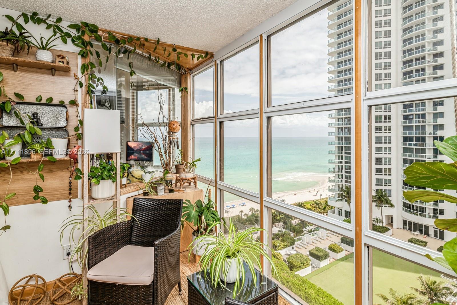 Enclosed sunroom featuring floor-to-ceiling windows, wood-finish wall paneling, and wood-finish flooring