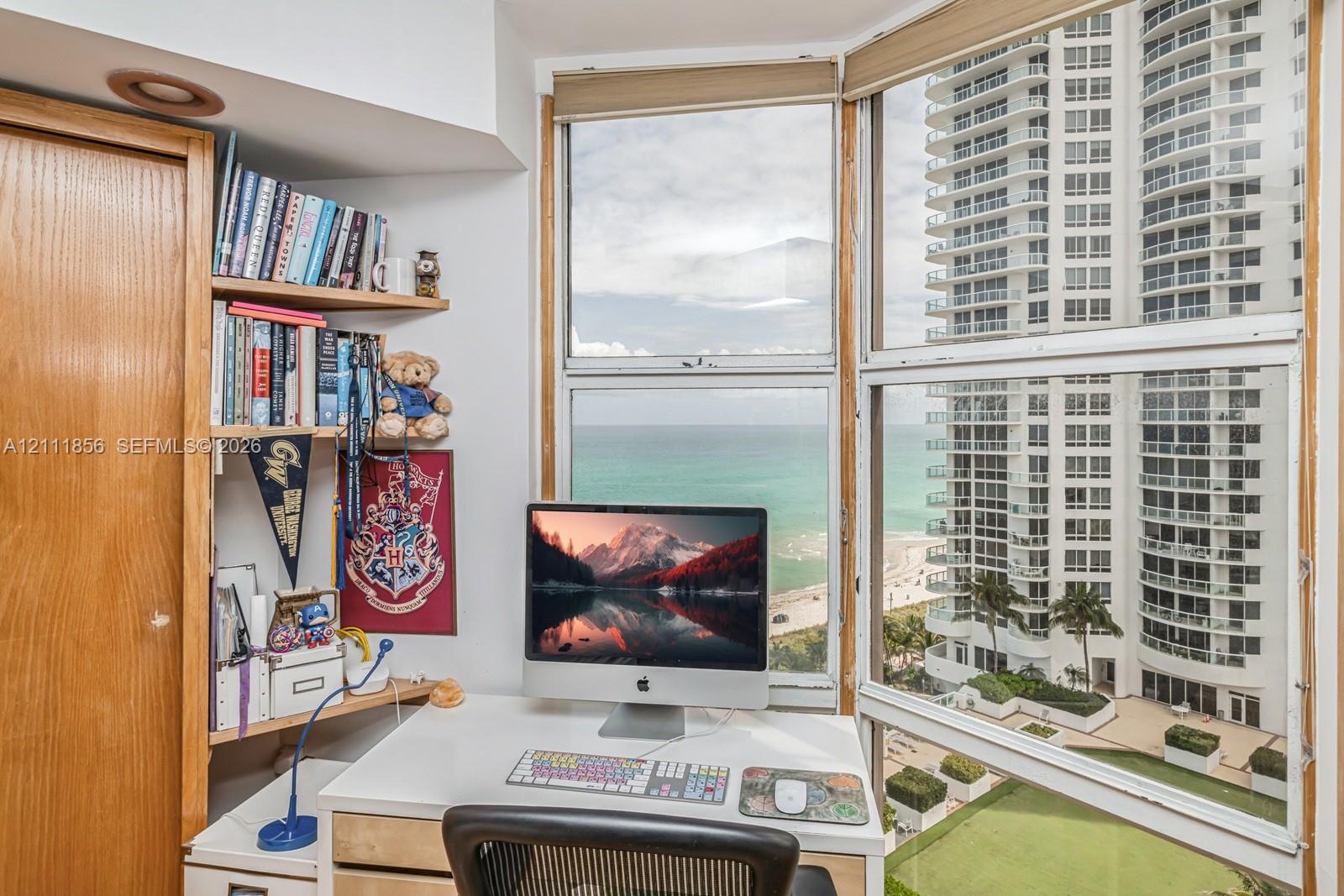 Floor-to-ceiling windows, built-in wooden shelving, and panoramic coastal scenery