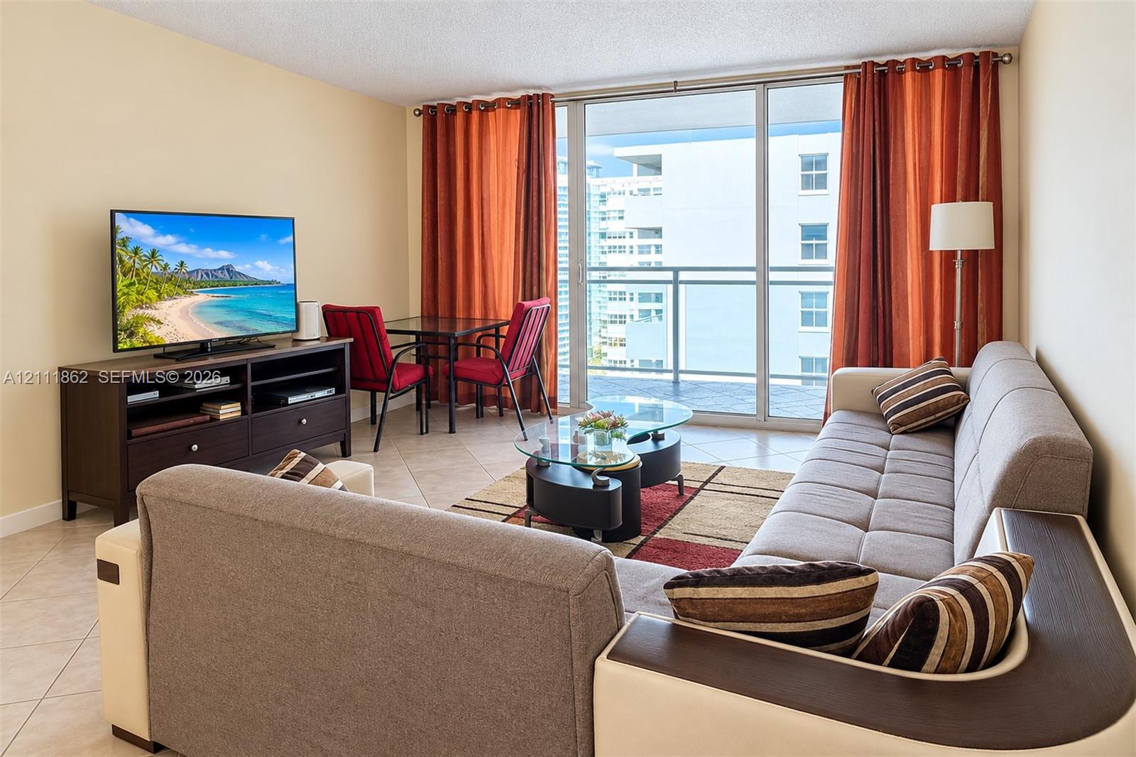 Living space featuring large-format ceramic tile flooring, floor-to-ceiling glass sliding doors, and a private balcony with metal railing Living space featuring large-format ceramic tile flooring, floor-to-ceiling glass sliding doors, and a private balcony with metal railing