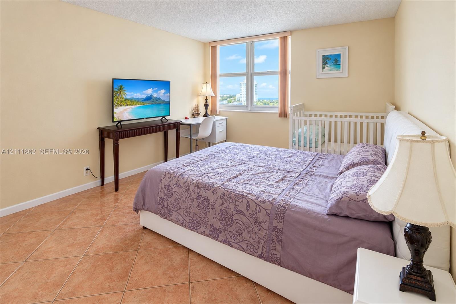 Large window with exterior coastal scenery, tile flooring, and textured ceiling finish