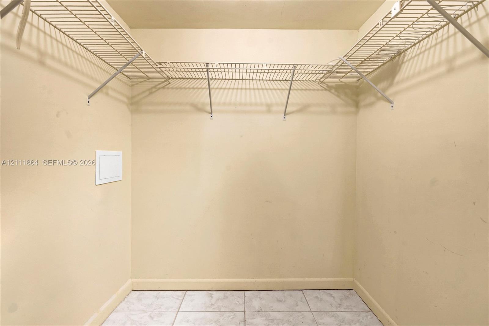 Storage area featuring white wire shelving and tile flooring