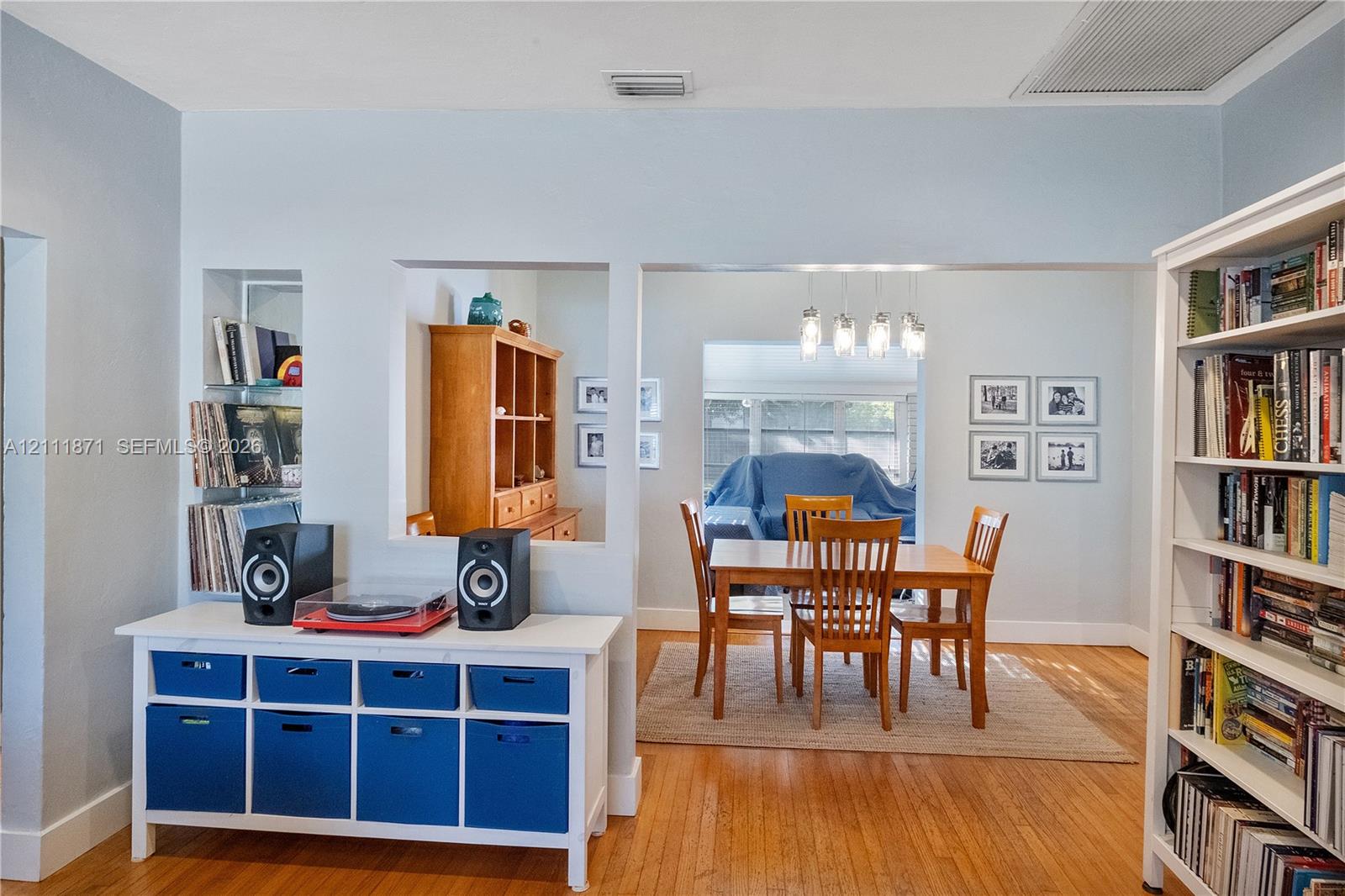 Living area featuring hardwood flooring, a recessed display niche, and a wall cutout opening