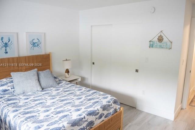 Interior space featuring neutral wall paint, wood-finish flooring, and sliding-panel closet doors Interior space featuring neutral wall paint, wood-finish flooring, and sliding-panel closet doors