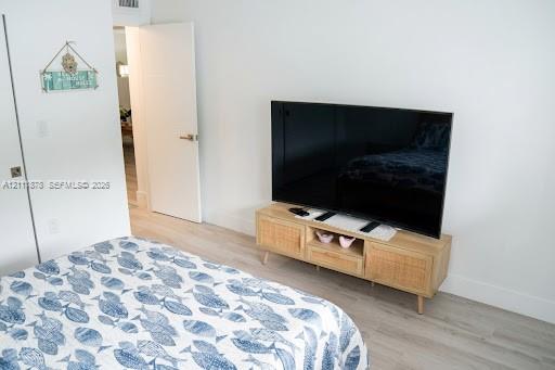 Wood-finish flooring, crisp white walls, and a solid-core interior door with satin nickel hardware