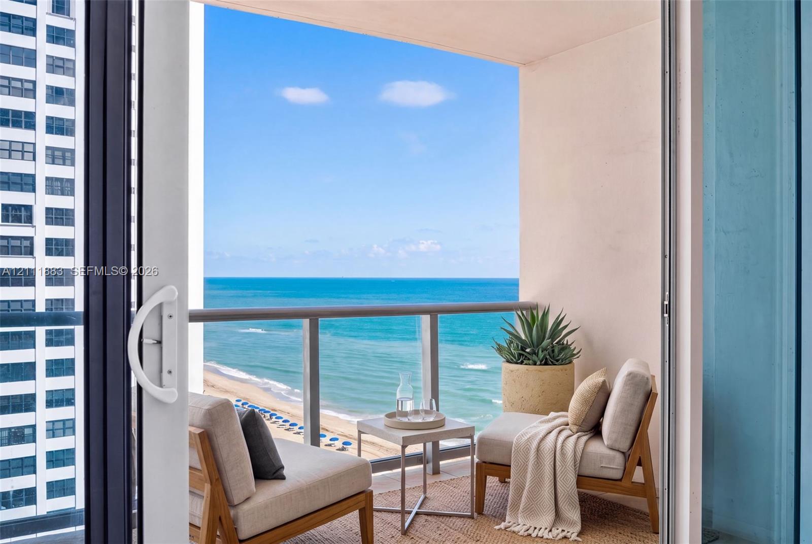 Private balcony featuring a glass-panel railing and open-air access to the oceanfront