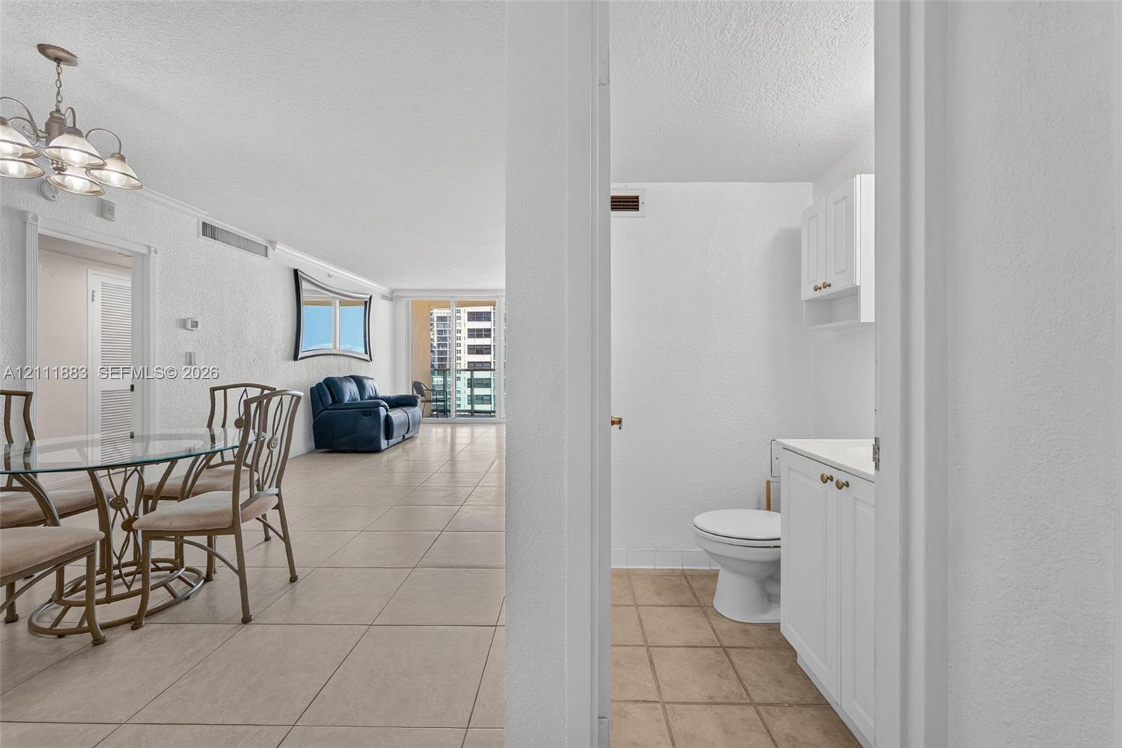 Interior space featuring ceramic tile flooring, a multi-arm chandelier, and sliding glass balcony doors
