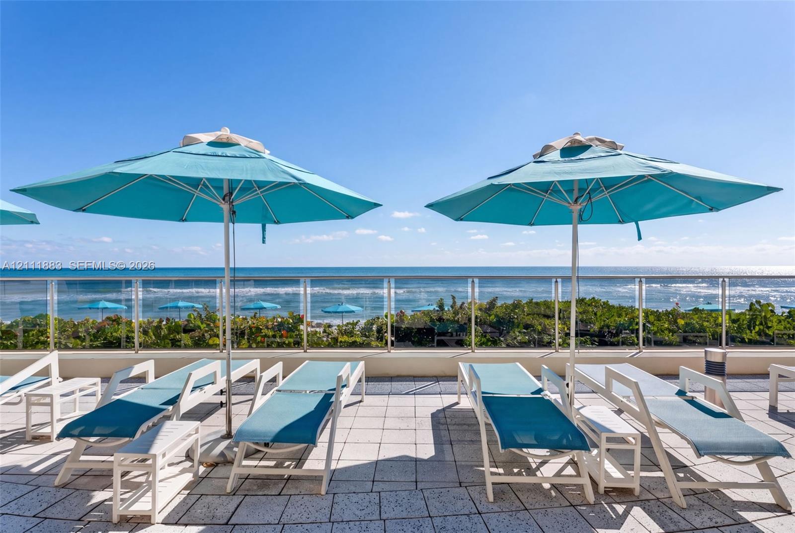 Outdoor terrace featuring stone tile flooring and a glass panel railing