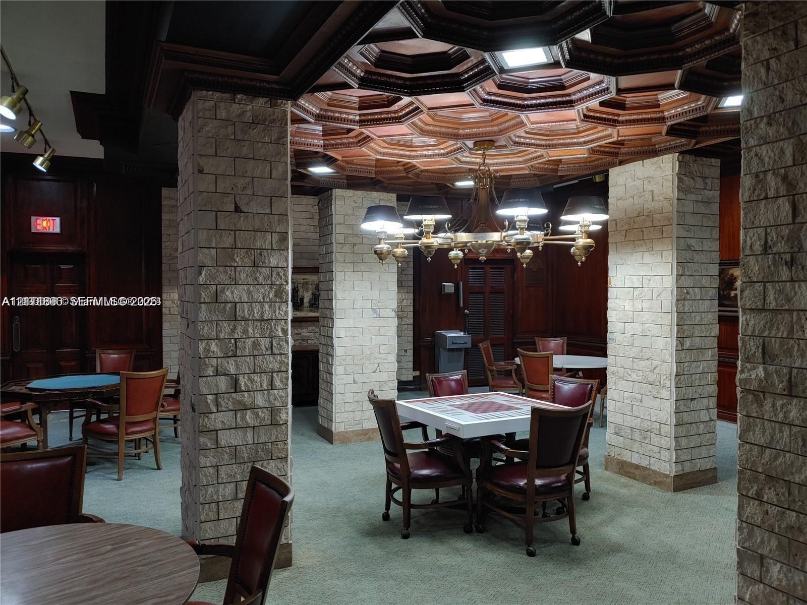 Custom coffered wood ceiling, stone-clad structural pillars, and dark wood-paneled walls