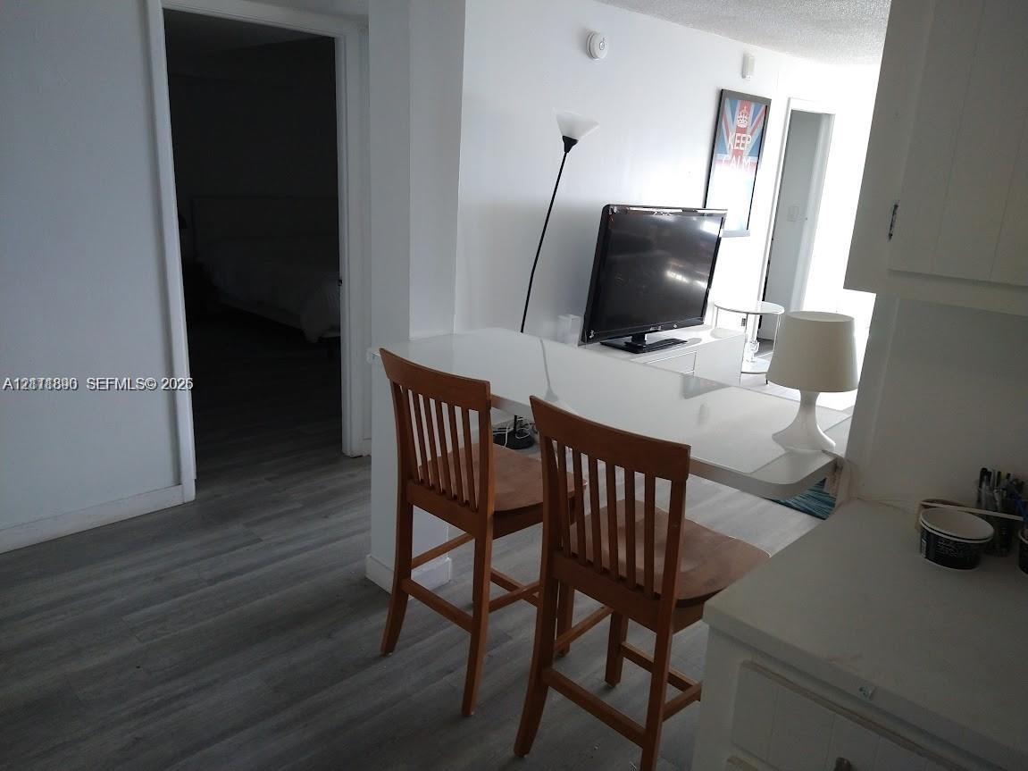 Interior featuring wood-finish flooring and a white, built-in breakfast bar Interior featuring wood-finish flooring and a white, built-in breakfast bar
