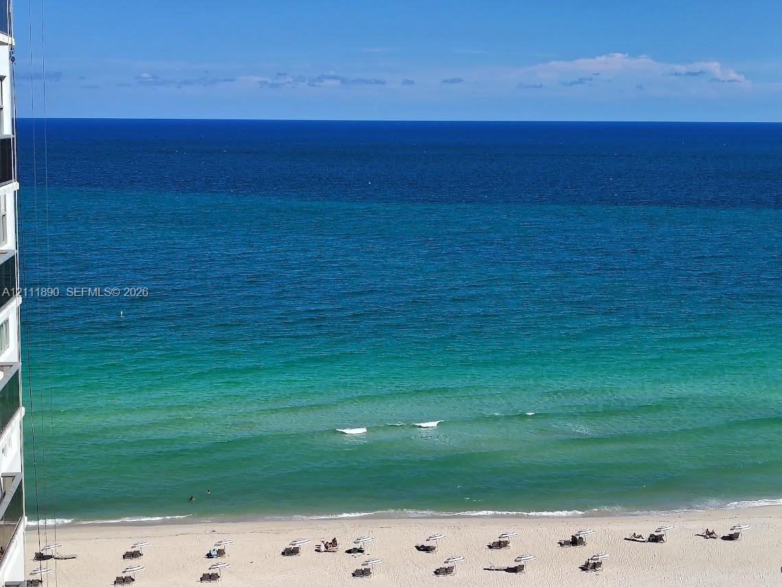 High-rise exterior featuring a direct oceanfront position, sand beach access, and panoramic coastal horizon High-rise exterior featuring a direct oceanfront position, sand beach access, and panoramic coastal horizon