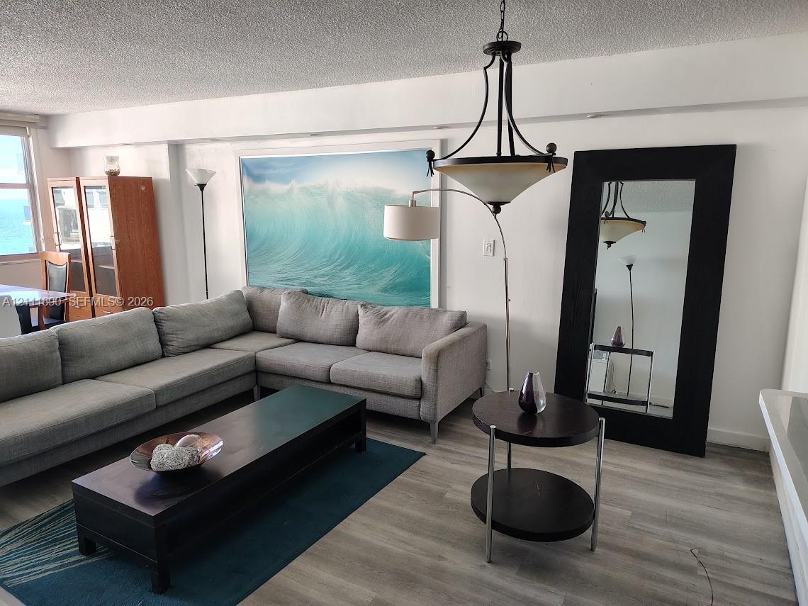 Wood-finish flooring, metal multi-arm chandelier, and neutral wall tones Wood-finish flooring, metal multi-arm chandelier, and neutral wall tones