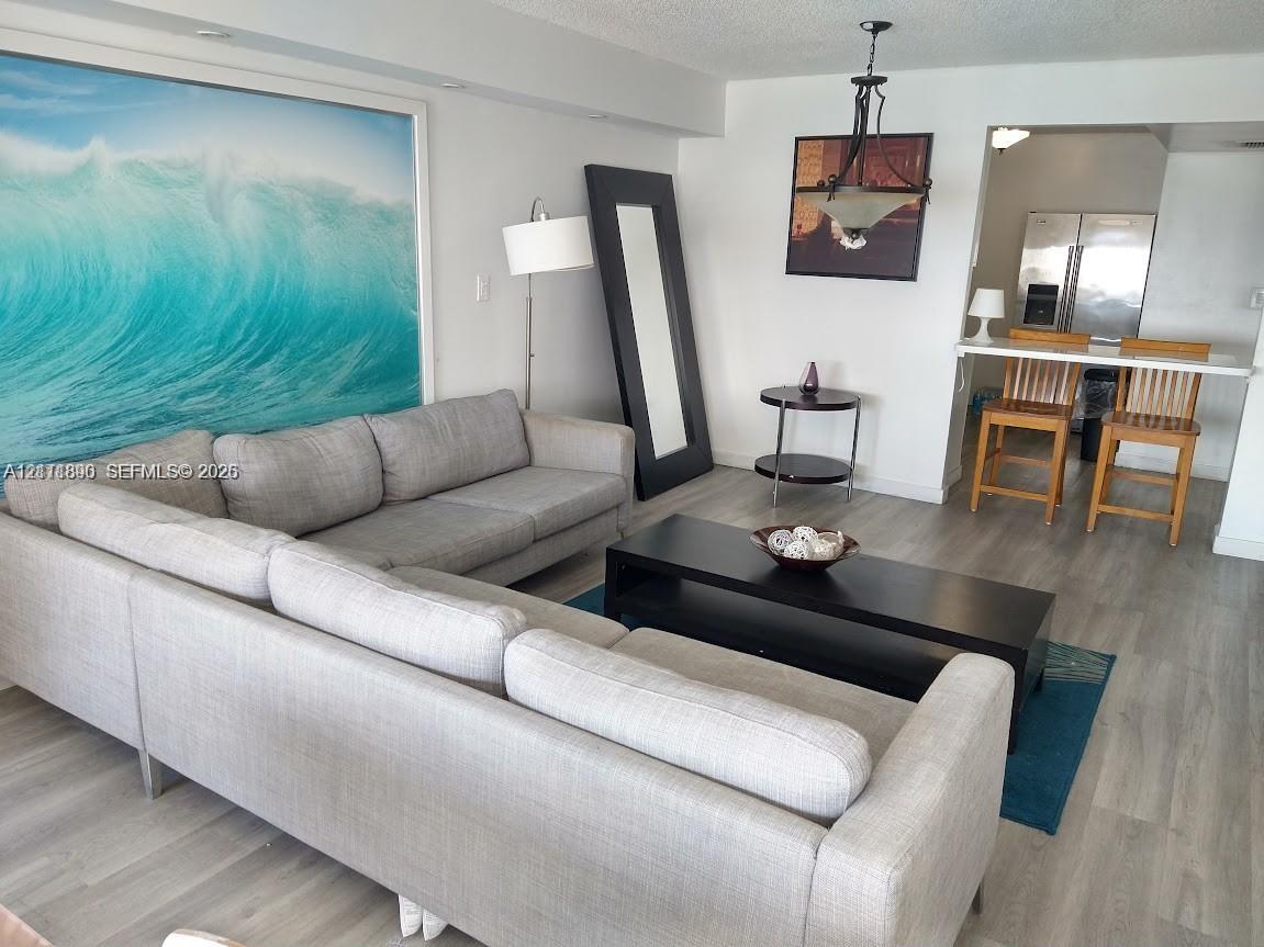 Wood-finish flooring, recessed lighting, and a suspended iron-frame light fixture Wood-finish flooring, recessed lighting, and a suspended iron-frame light fixture