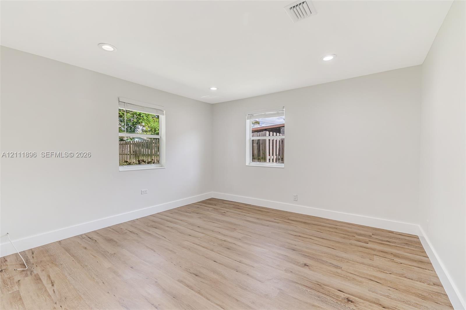 Interior room featuring wood-finish flooring, recessed lighting, and dual windows