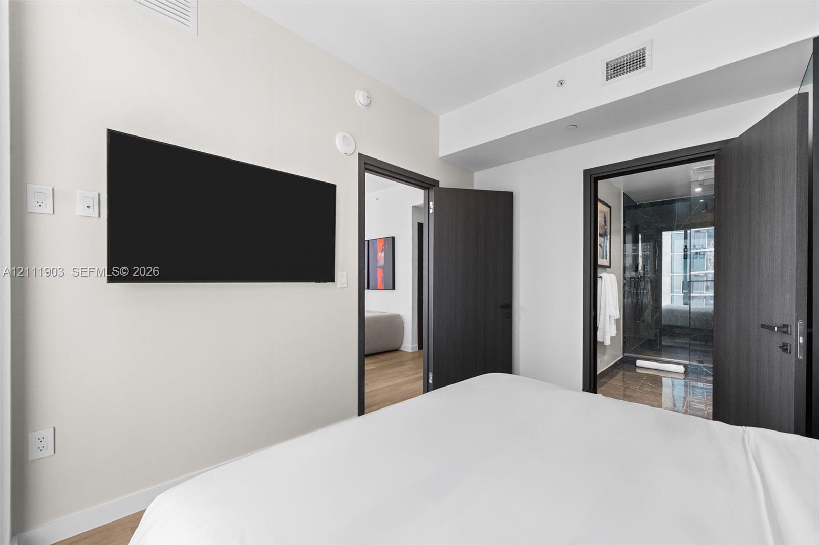 Interior room featuring dark-toned solid core doors, minimalist hardware, and wood-finish flooring