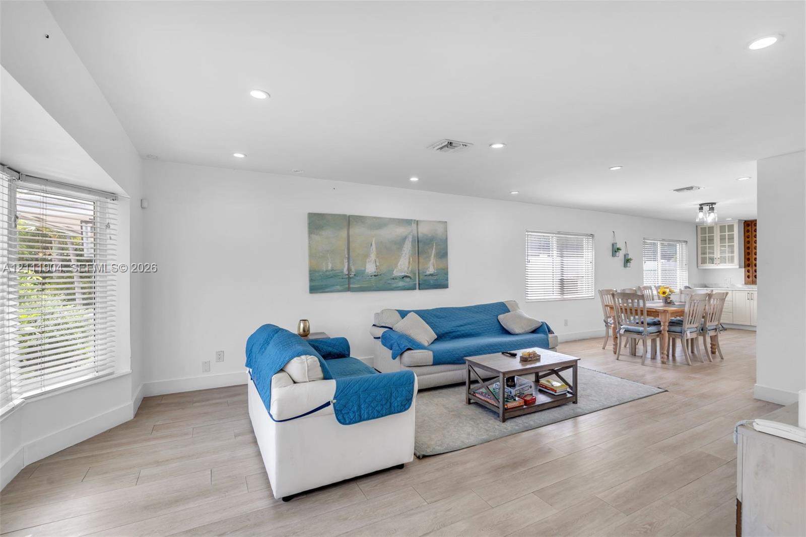 Open-concept interior featuring wood-finish flooring, recessed lighting, and a bay window