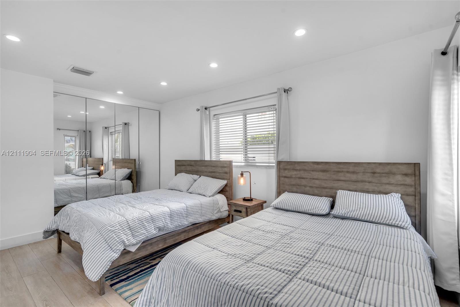 Bedroom featuring wood-finish flooring, recessed lighting, and mirrored sliding-door closet