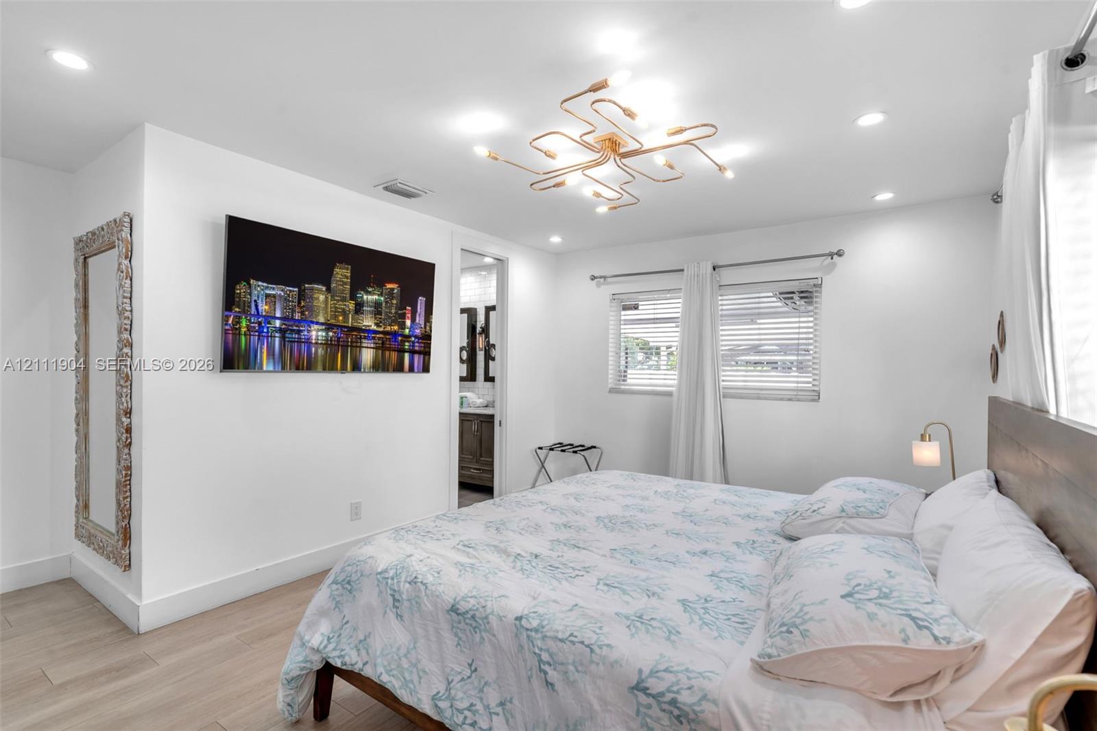 Bedroom featuring wood-finish flooring, recessed lighting, and a multi-arm geometric ceiling fixture