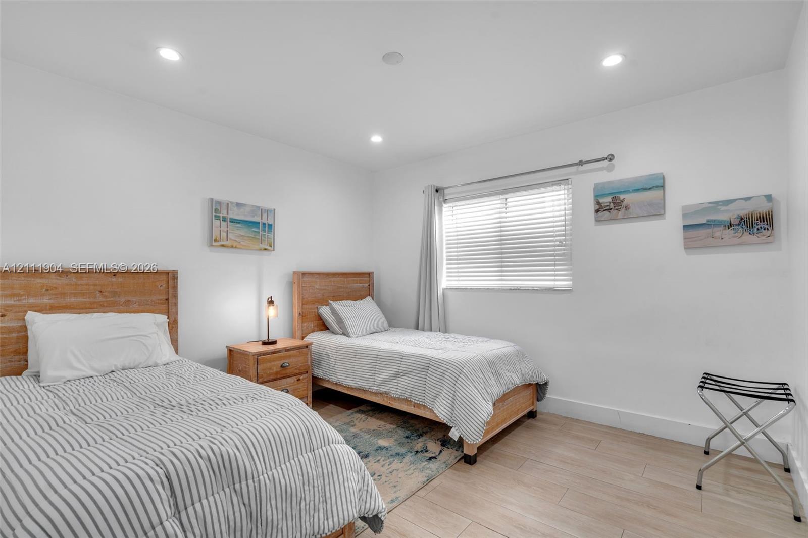 Room featuring recessed lighting, wood-finish flooring, and a window with horizontal blinds