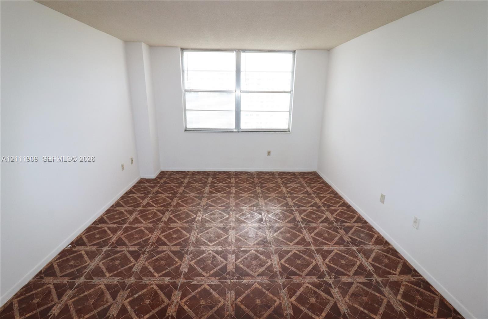 Interior space featuring patterned tile flooring and a large aluminum-frame window