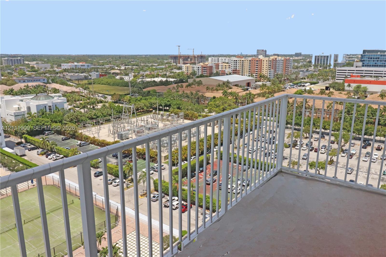 Private balcony featuring white metal railings and concrete flooring