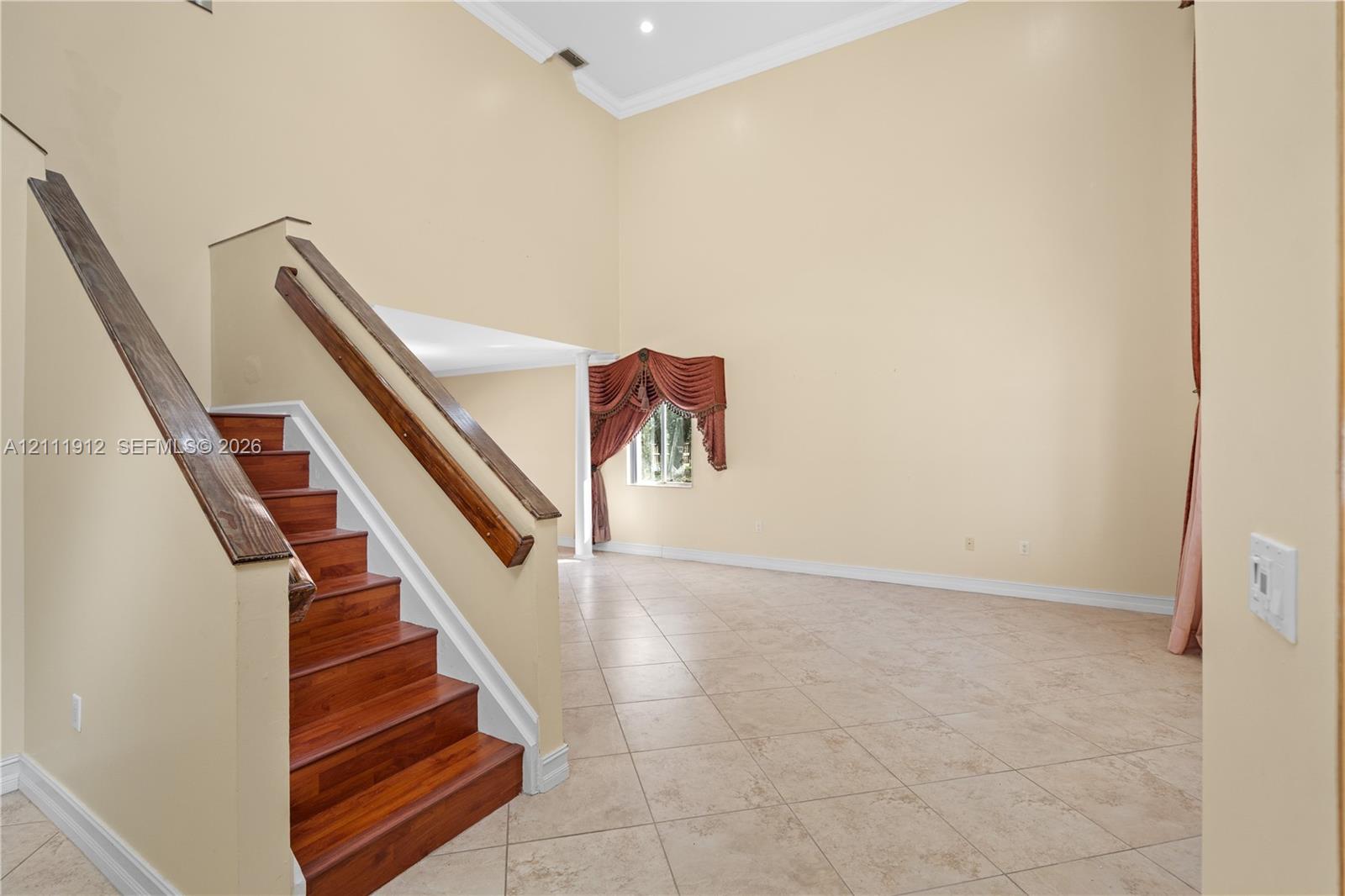 Vaulted ceilings, staircase with wood-finish treads and handrails, and tile flooring