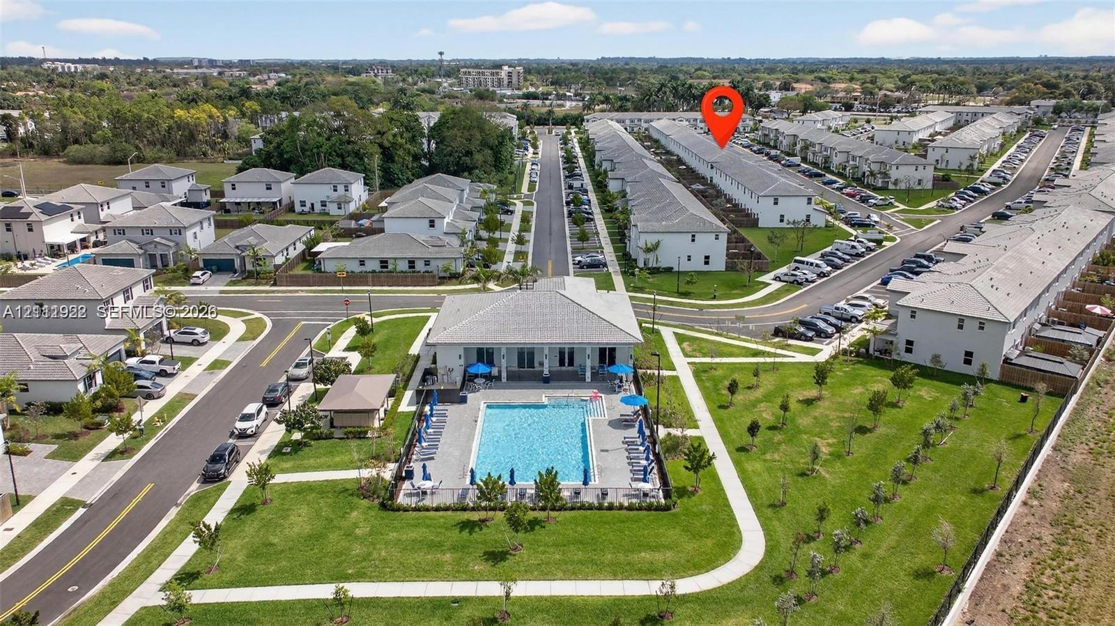 Community pool featuring a paved deck and professional landscaping