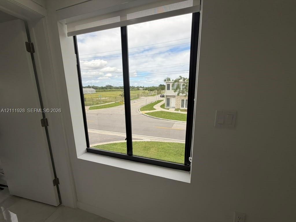 Large, black-framed picture window featuring a retractable roller shade