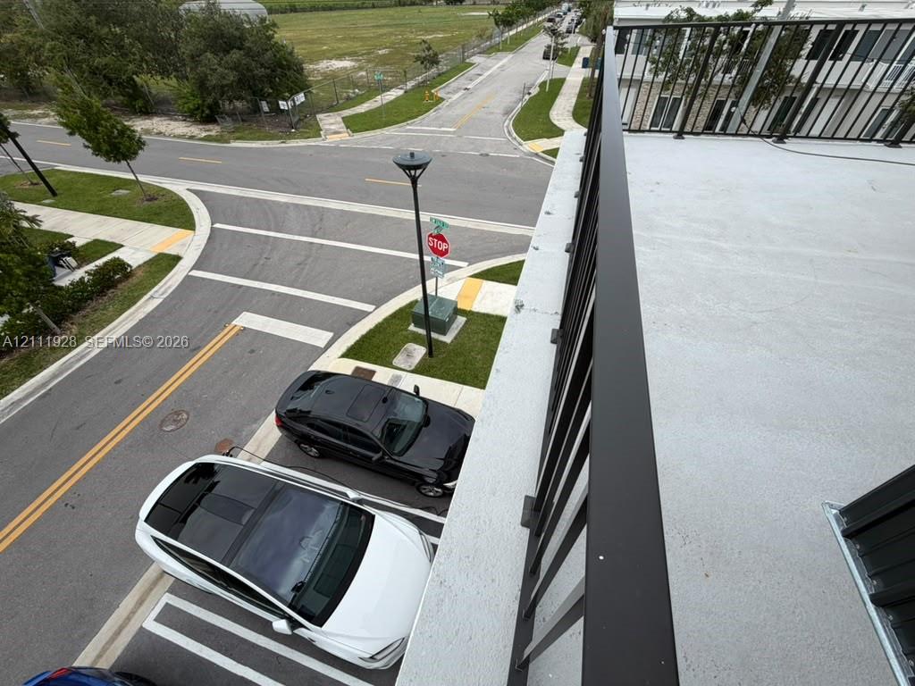 Elevated balcony featuring a smooth surface deck and a black metal railing