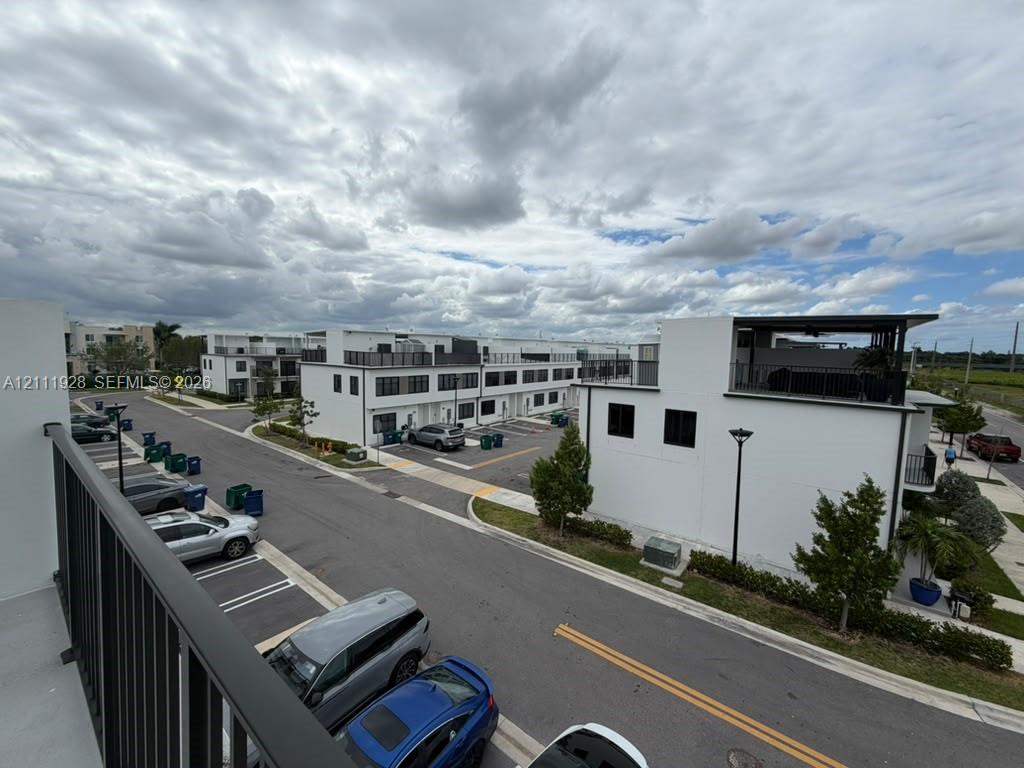 Contemporary multi-story architecture featuring stucco exterior finishes, flat rooflines, integrated rooftop terraces with dark metal railings, and black window frames