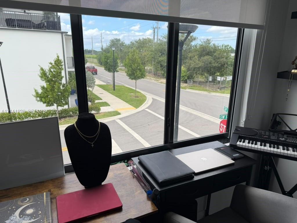 Floor-to-ceiling windows with black frames and an integrated retractable roller shade