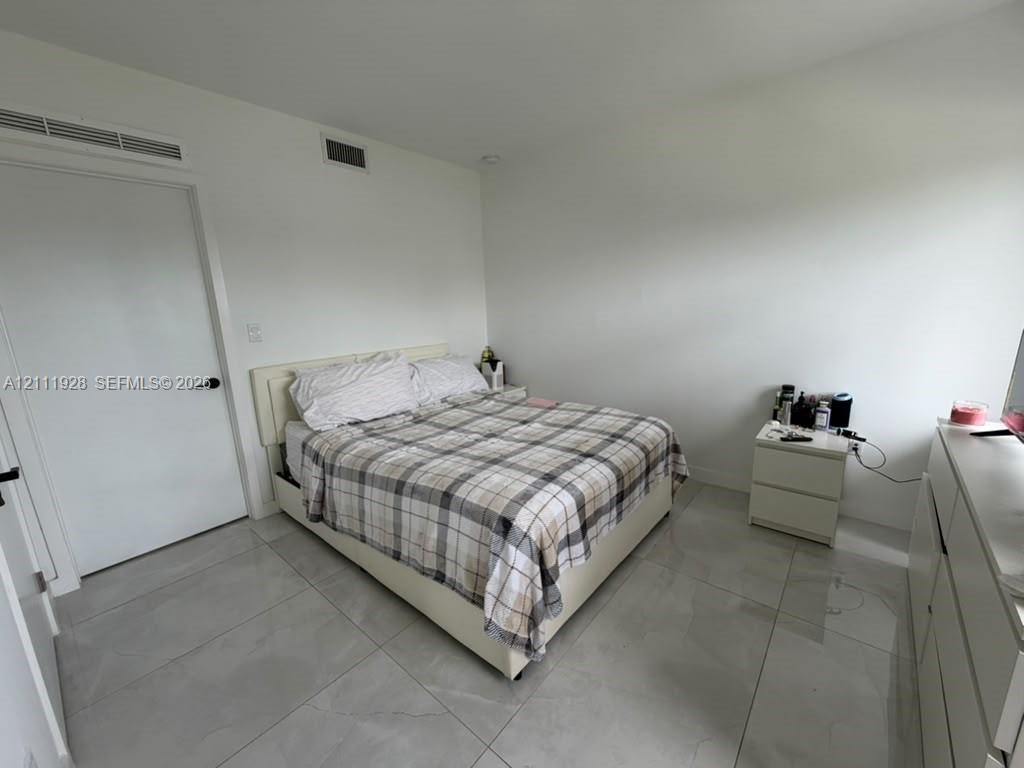 Large-format tile flooring, white interior walls, and solid-core doors with matte black hardware