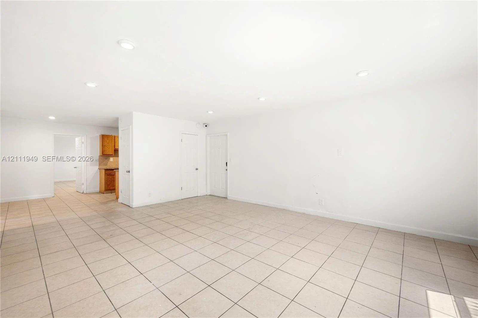 Interior space featuring neutral tile flooring, recessed lighting, and white walls