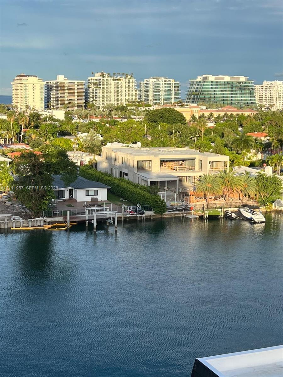 Waterfront property featuring private dockage, concrete seawall, mature perimeter landscaping, and multi-level structural design